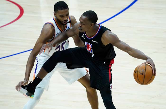 Apr 8, 2021; Los Angeles, California, USA; LA Clippers guard Rajon Rondo (4) keeps the ball away from Phoenix Suns forward Mikal Bridges (25) during the fourth quarter at Staples Center. Mandatory Credit: Robert Hanashiro-USA TODAY Sports